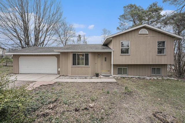 tri-level home featuring an attached garage, driveway, and roof with shingles