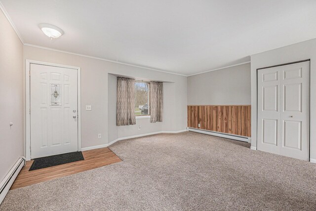 carpeted entrance foyer featuring a baseboard radiator, baseboards, and ornamental molding