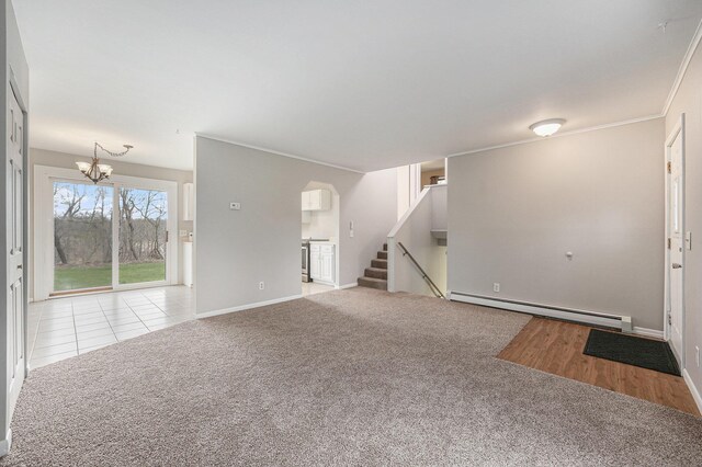 unfurnished living room with a baseboard heating unit, arched walkways, a chandelier, stairway, and carpet floors