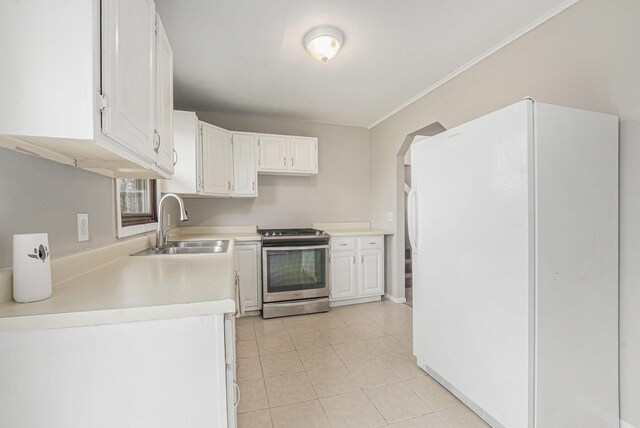 kitchen featuring white cabinets, a sink, electric range, freestanding refrigerator, and light tile patterned floors