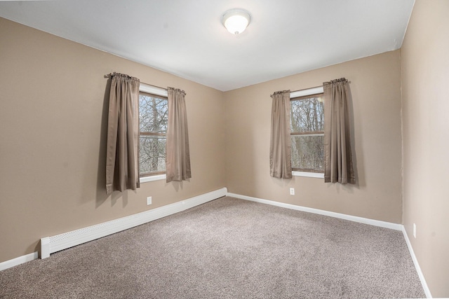 carpeted empty room with baseboard heating and baseboards