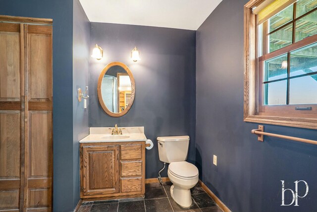 bathroom featuring tile patterned flooring, vanity, toilet, and baseboards