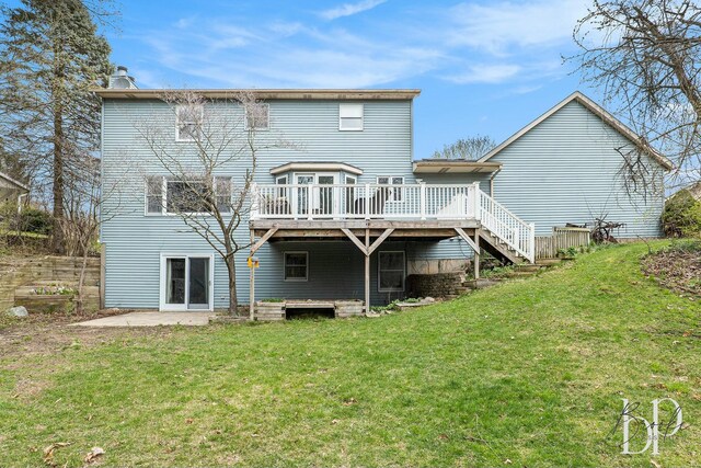 rear view of house with a chimney, fence, a wooden deck, a lawn, and stairs