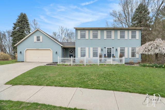colonial home featuring an attached garage, driveway, a front yard, and fence private yard