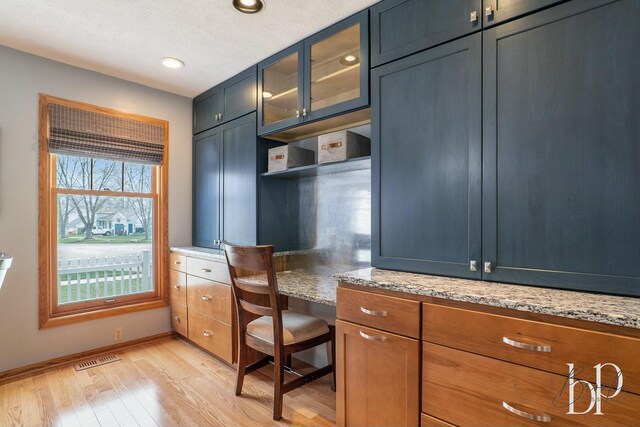 office area featuring recessed lighting, built in study area, light wood finished floors, visible vents, and baseboards