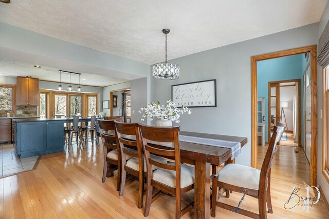 dining room featuring light wood-style floors and a notable chandelier