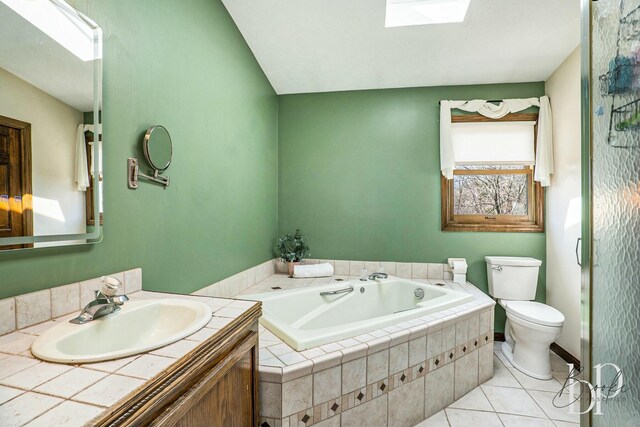 bathroom featuring a garden tub, tile patterned floors, a skylight, vanity, and toilet