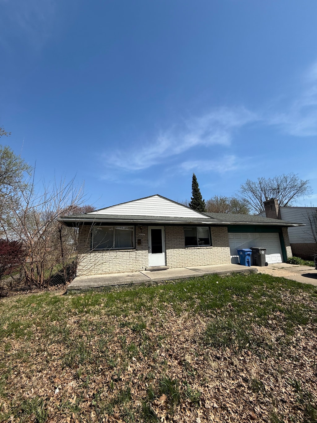 4123 Burton St, Inkster, MI 48141 - view of front facade with a front lawn, concrete driveway, brick siding, and an attached garage