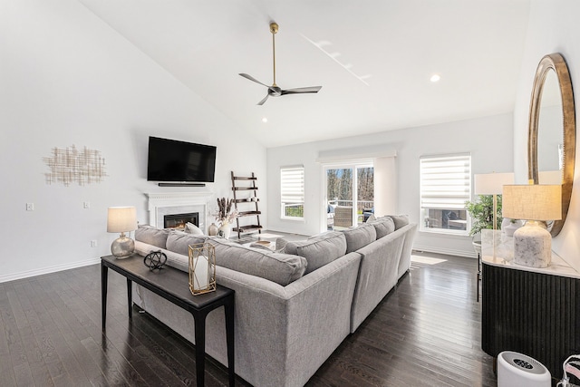 living room featuring baseboards, ceiling fan, high vaulted ceiling, and dark wood-type flooring