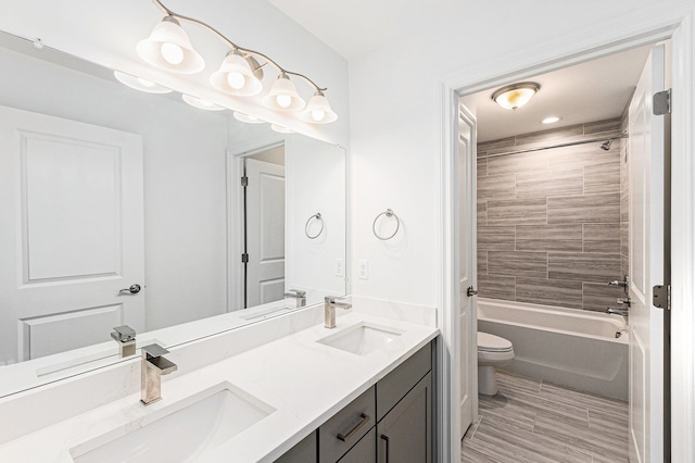 full bathroom featuring double vanity, toilet, shower / bath combination, and a sink