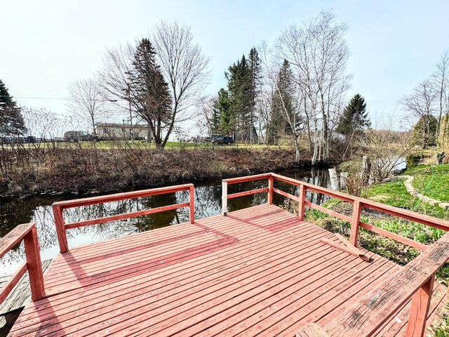 wooden terrace featuring a water view