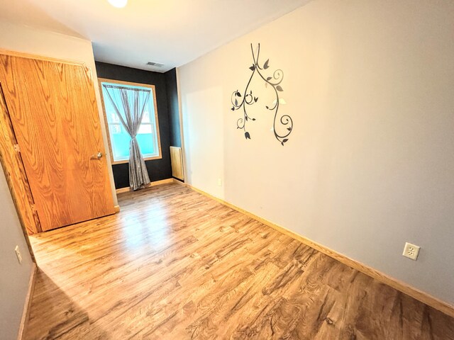 unfurnished room featuring baseboards and wood finished floors