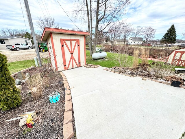 view of patio with an outbuilding and a shed