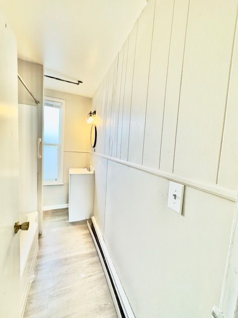 bathroom with baseboard heating, baseboards, and wood finished floors