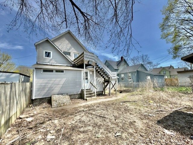 back of property with fence and entry steps