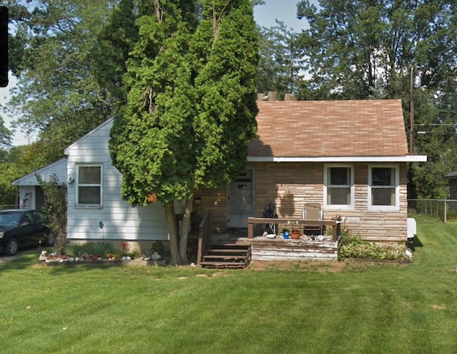 back of property featuring stone siding and a deck