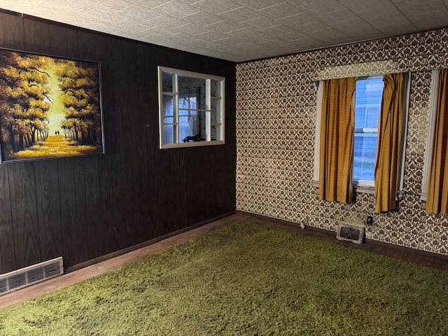 empty room with baseboards and wallpapered walls