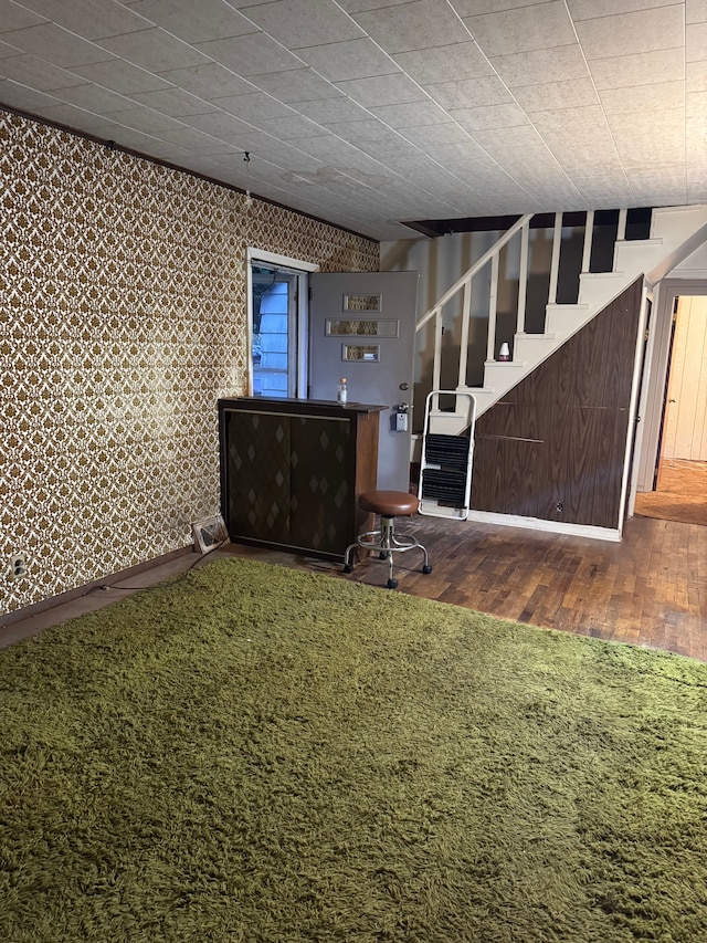 unfurnished living room with wood finished floors and stairway