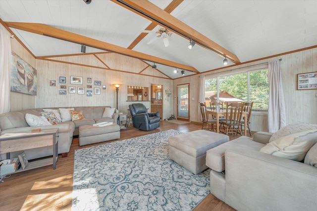 living area featuring lofted ceiling with beams, wood finished floors, and a healthy amount of sunlight