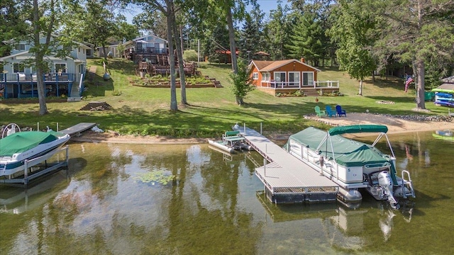 dock area with boat lift, a yard, and a water view