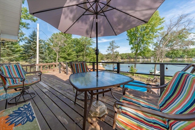 wooden deck featuring a water view and outdoor dining area