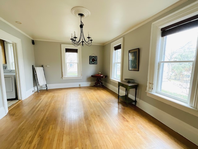 323 N Marshall Ave, Marshall, MI 49068 - unfurnished dining area with ornamental molding, an inviting chandelier, washer / clothes dryer, and a healthy amount of sunlight
