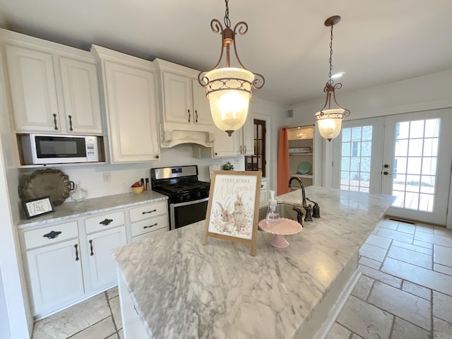 323 N Marshall Ave, Marshall, MI 49068 - kitchen with french doors, a sink, stone tile flooring, gas stove, and white microwave