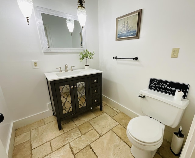 323 N Marshall Ave, Marshall, MI 49068 - half bath with toilet, baseboards, stone tile flooring, and vanity