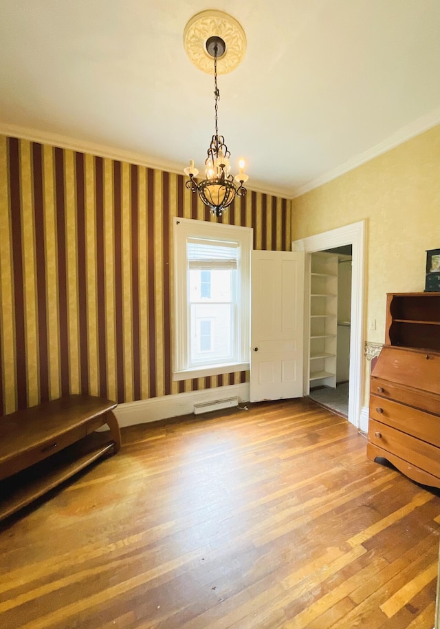 323 N Marshall Ave, Marshall, MI 49068 - unfurnished dining area featuring wallpapered walls, an inviting chandelier, wood finished floors, visible vents, and crown molding