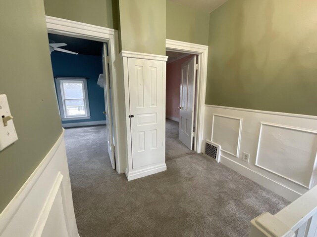 323 N Marshall Ave, Marshall, MI 49068 - hallway with a wainscoted wall, visible vents, and dark carpet