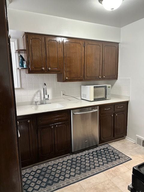 23226 Edward St, Dearborn, MI 48128 - kitchen with stainless steel dishwasher, white microwave, a sink, and light countertops