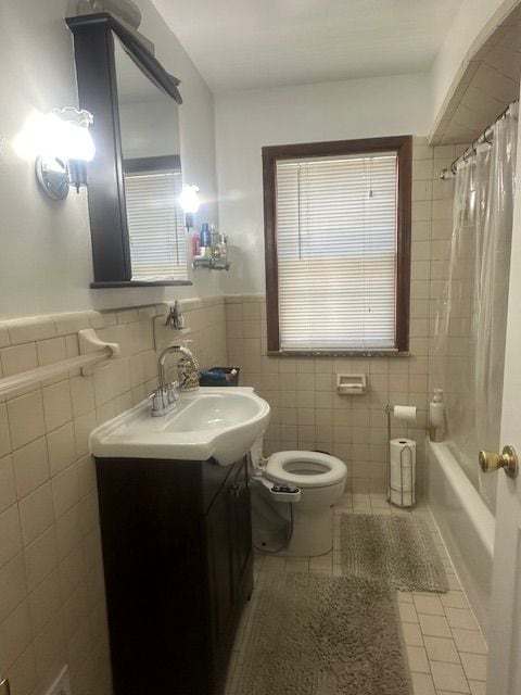23226 Edward St, Dearborn, MI 48128 - full bathroom featuring tile patterned flooring, tile walls, toilet, vanity, and wainscoting