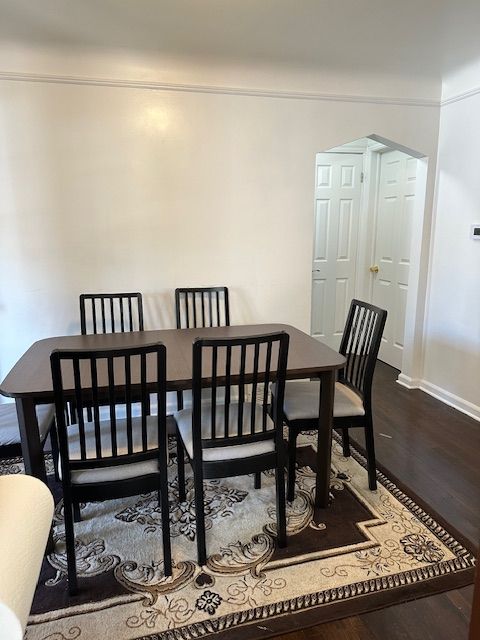 23226 Edward St, Dearborn, MI 48128 - dining area with dark wood-type flooring, arched walkways, and baseboards
