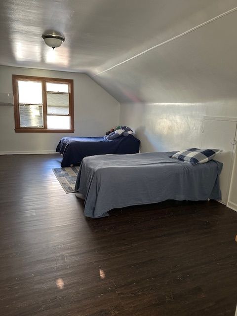 23226 Edward St, Dearborn, MI 48128 - bedroom with dark wood-type flooring, lofted ceiling, and baseboards