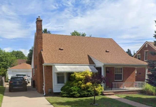 23226 Edward St, Dearborn, MI 48128 - view of front of house featuring brick siding, a front lawn, a chimney, a porch, and a detached garage