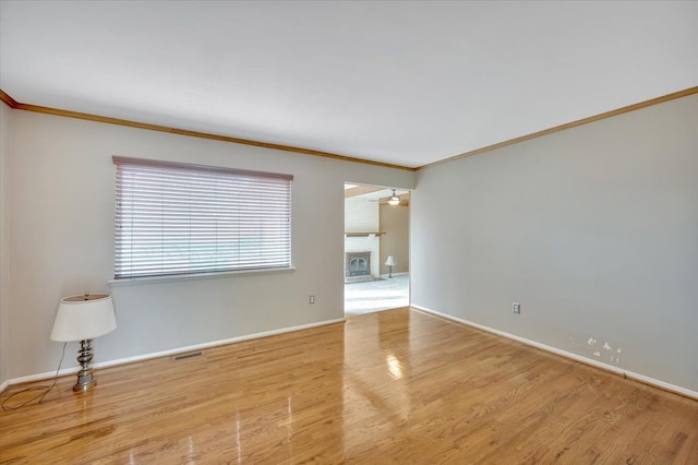 2946 Athena Dr, Troy, MI 48083 - unfurnished room with crown molding, baseboards, a fireplace, and wood finished floors