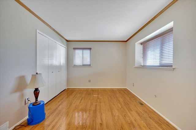 2946 Athena Dr, Troy, MI 48083 - unfurnished bedroom with crown molding, baseboards, visible vents, and wood finished floors