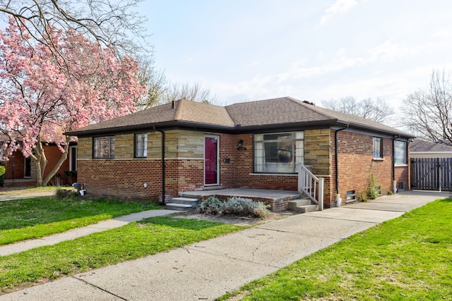 bungalow-style house with brick siding, a front lawn, and roof with shingles