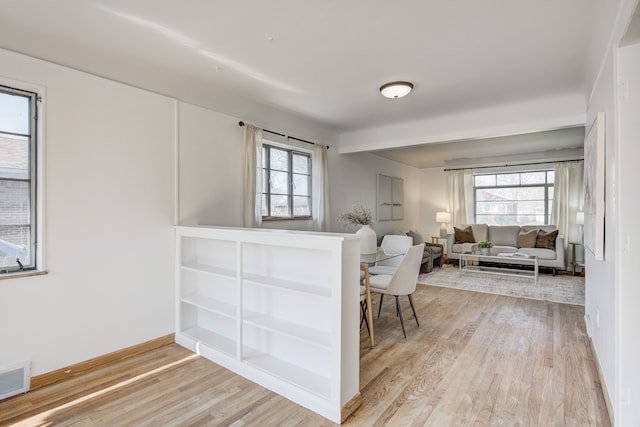 interior space with visible vents, light wood finished floors, and baseboards