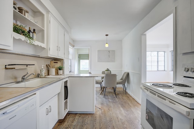 kitchen with light wood-type flooring, a sink, light countertops, white appliances, and white cabinetry