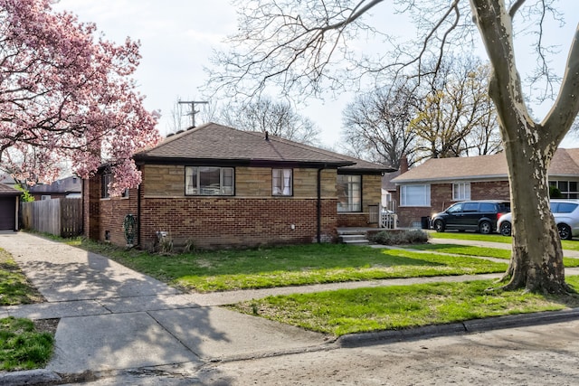 bungalow-style home featuring a garage, fence, a front yard, brick siding, and concrete driveway