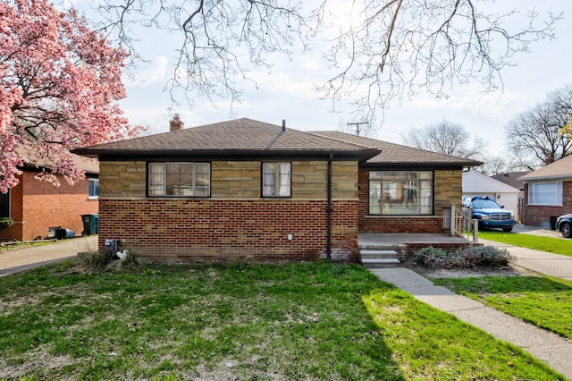 bungalow with a shingled roof, a chimney, a front lawn, and brick siding