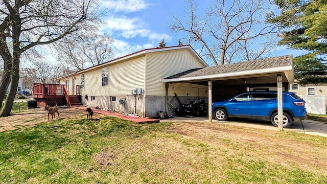 view of side of home featuring driveway, an attached carport, a yard, and a deck