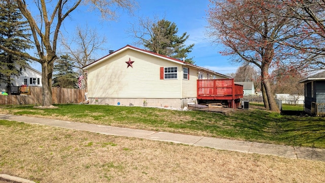 view of home's exterior featuring fence, a wooden deck, a lawn, and crawl space