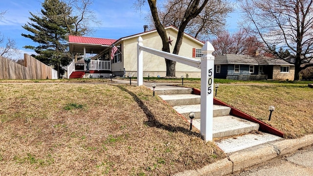 view of front of home featuring a front lawn, fence, and covered porch