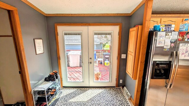 doorway with crown molding, french doors, a textured ceiling, and visible vents