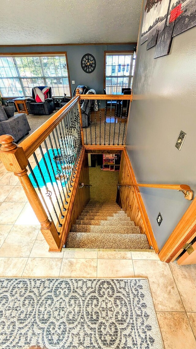 stairway featuring a textured ceiling