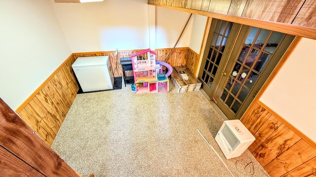 recreation room with wainscoting and wood walls