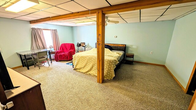 bedroom with carpet floors, a paneled ceiling, and baseboards