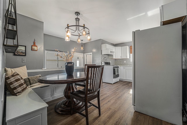 dining space featuring dark wood finished floors and a chandelier